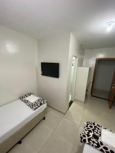 1 dormitorio con 1 cama y TV de pantalla plana en Pousada Dona Lia, en Uberlândia