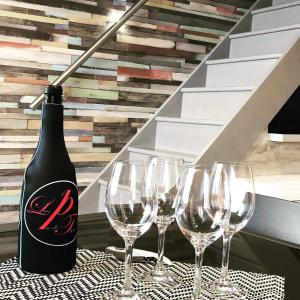 a bottle of wine sitting on a table with wine glasses at Appartement Le Taquet in Marseillan +3 photos