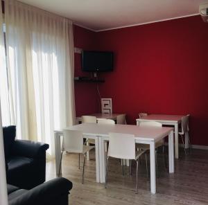 a dining room with a white table and chairs at Ostello La Sosta in Contrada Anselmi