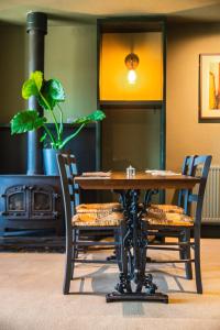 White Hart Inn في Brightling: طاولة وكراسي مع موقد في الغرفة