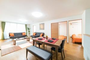 a living room with a table and chairs and a couch at Kamon INN OSAKA in Osaka