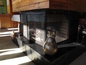 um vaso sentado numa prateleira numa lareira em Hosteria Santa Rita em San Carlos de Bariloche