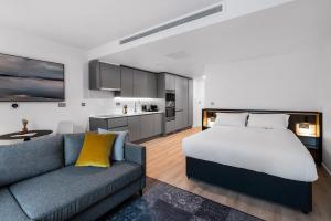 a bedroom with a bed and a couch and a kitchen at CitySuites 2 Aparthotel in Manchester +79 photos