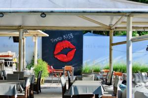 a stage with tables and chairs and a red kiss sign at Sanae Beach Hua Hin in Khao Tao