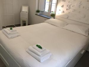 un letto bianco con due asciugamani e una finestra di G30 Finalborgo Lodging'n Bike Box a Finale Ligure
