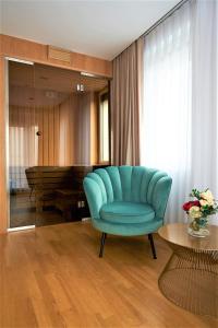 sala de estar con silla azul y mesa en Hotel Glory en Oradea