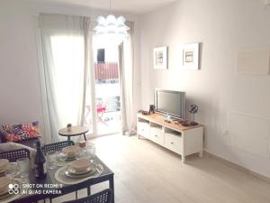 a living room with a television on a dresser at Vuestro apartamento del Sur in Fuengirola