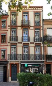 een appartementencomplex met balkons in een stadsstraat bij Residence le Pastel Jeanne d'Arc in Toulouse