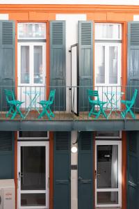 een gebouw met groene stoelen op een balkon bij Residence le Pastel Jeanne d'Arc in Toulouse