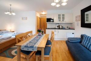 a kitchen and living room with a table and a couch at Haus Lowe Apartment Erdgeschoss 1 in Filzmoos