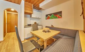 uma sala de jantar e cozinha com mesa e cadeiras em Appartement Slope & Smile em Saalbach-Hinterglemm