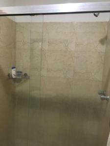 y baño con ducha y puerta de cristal. en apartosuite en Caracas