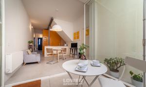 ein Wohnzimmer mit einem weißen Tisch im Zimmer in der Unterkunft Casinhas da Beira Mar by Home Sweet Home Aveiro in Aveiro