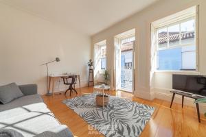 ein Wohnzimmer mit Sofa und Fernseher in der Unterkunft Casinhas da Beira Mar by Home Sweet Home Aveiro in Aveiro
