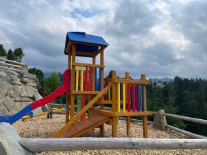 een speeltuin met een glijbaan en een houten speelplaats bij Tatrzanska Polana - Mountain View, Free Parking & WiFi in Zakopane