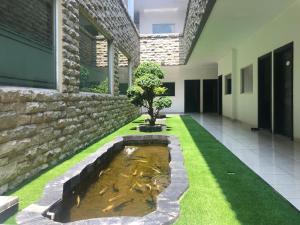 un étang de carpes koï en face d'un bâtiment dans l'établissement Hotel Sinar 3, à Sedati