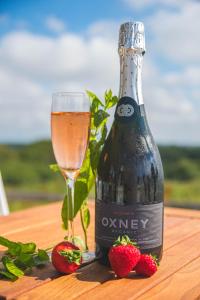 eine Flasche Wein und Erdbeeren auf dem Tisch in der Unterkunft White Hart Inn in Brightling