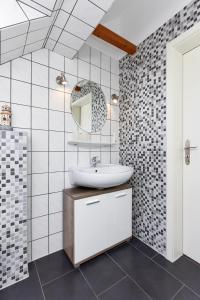 a bathroom with a sink and a mirror at Ferienwohnungen im Haus Friesische Weite in Wangerland +29 photos