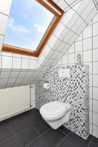 a bathroom with a toilet and a window at Ferienwohnungen im Haus Friesische Weite in Wangerland