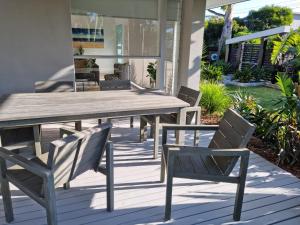 a wooden table and chairs on a patio at Beachside Rosebud Retreat with *Wheelchair access* in Rosebud