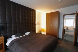 a bedroom with a large bed with a large headboard at Fosshotel Stykkisholmur in Stykkishólmur