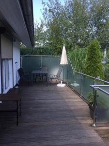 a deck with a table and chairs and an umbrella at Ostseebrise 1 in Zingst