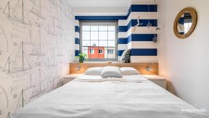 a bedroom with a large bed with blue and white stripes at Apartament 117 HVILE in Gdańsk