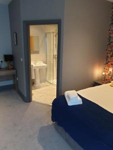 a bedroom with a bed and a bathroom with a sink at The Strutt Arms in Belper +25 photos