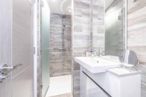 ein weißes Bad mit einem Waschbecken und einer Dusche in der Unterkunft LUXURY LODGE - STUNNING RIVER VIEWS & HOT TUB in Dorney