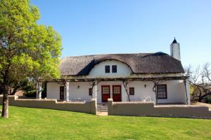 a white house with a thatched roof at Manley Wine Estate in Tulbagh