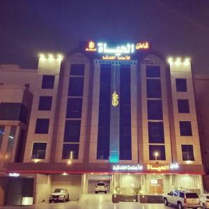 a building with cars parked in front of it at night at Shaty Alhayat Hotel Suites in Jeddah