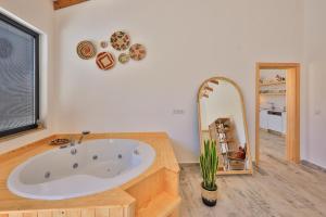 a bathroom with a large tub and a mirror at Golden Lighthouse Hotel in Patara