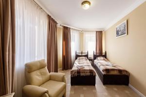 a hotel room with two beds and a chair at Patkovski in Bukovel