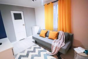 a living room with a couch and orange curtains at Old Town Apartments Sandomierz in Sandomierz