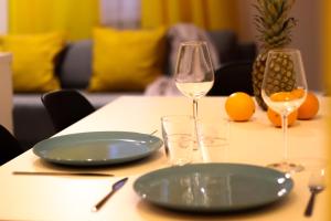 a table with a plate and two glasses of wine at Old Town Apartments Sandomierz in Sandomierz