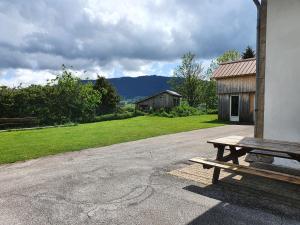 a wooden picnic table sitting next to a building at Gîte du Grand Cher in Les Rousses