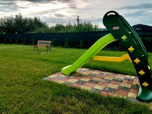 a green slide in the grass next to a bench at Pensiunea Casa Albă in Beclean