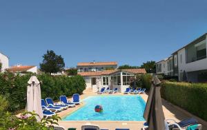 a pool with chairs and a ball in the water at LA JOLIE BRISE APPARTEMENT DANS RÉSIDENCE AVEC PISCINE in La Flotte