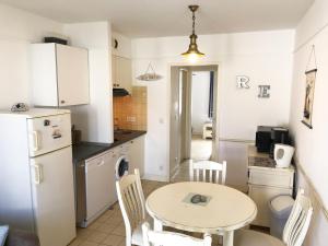 a kitchen with a table and a small table and chairs at LA JOLIE BRISE APPARTEMENT DANS RÉSIDENCE AVEC PISCINE in La Flotte