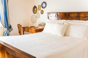 a bedroom with a white bed with a wooden headboard at Ca' De Memi in Piombino Dese