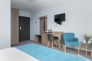 Habitación de hotel con cama, escritorio y TV. en Azul, en Grzybowo