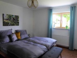 a bedroom with a bed and a window with blue curtains at Ferienwohnung Sonnenplatzl in Michelsneukirchen