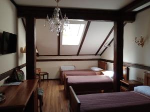 a bedroom with two beds and a chandelier at Hotel Fortetsya Hetmana in Hatne