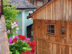a wooden house with flowers in front of it at Pension Cafe zum Mühlbach in Hallstatt