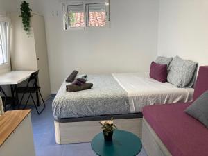 salon z dwoma łóżkami i stołem w obiekcie Malagueña Salerosa "Apartamento - estudio con terraza" En casa típica de 1 a 4 dormitorios w Maladze