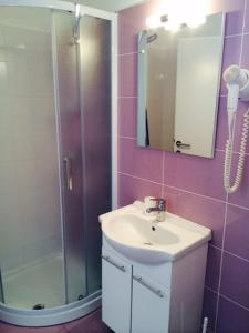 a bathroom with a sink and a shower and a mirror at Solaria Apartments Porec in Poreč