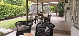 a patio with chairs and a table on a porch at Kimi's Cottage in Simondium