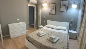 ボローニャにあるMarconi 30 Apartmentのベッドとタオル2枚のある寝室