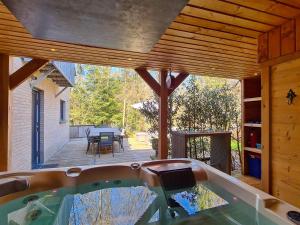 a hot tub in a house with a patio at Entre l'eau in Durbuy +19 photos