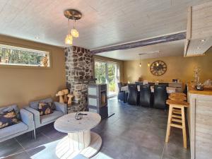 a living room with a stone fireplace and a table at Entre l'eau in Durbuy